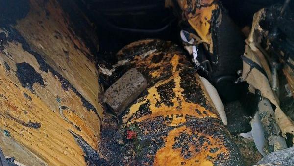 The brick lying on the burnt rear seats of the police car