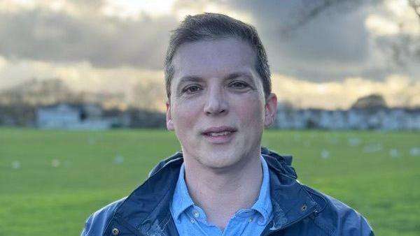 Gavin Chambers in open-necked blue shirt