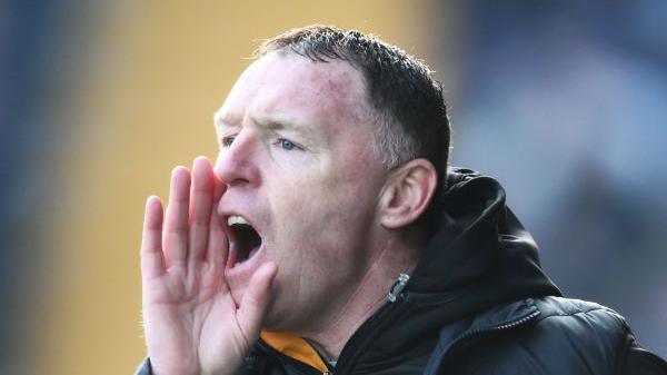 Graham Coughlan with his right hand cupped to his mouth to shout at his players from the touchline