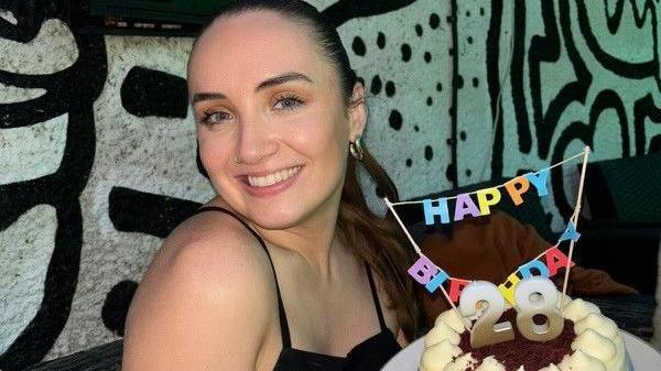 Natalie Earley smiling with her 28th birthday cark