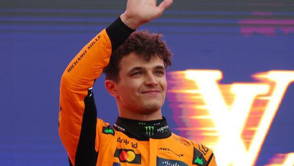 Lando Norris waves on the podium as he celebrates winning the Australian Grand Prix