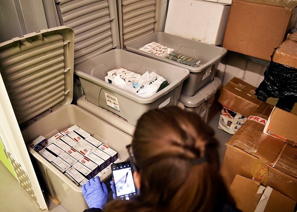 A picture taken at Richardson's home, which shows an officer taking a picture of boxes of medication in plastic boxes in her home. 