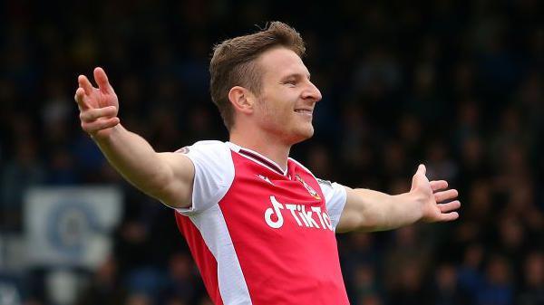 Paul Mullin. with arms outstretched, celebrates a goal for Wrexham