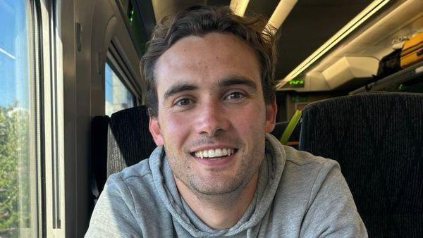 Henry Tufnell MP smiles on a train 