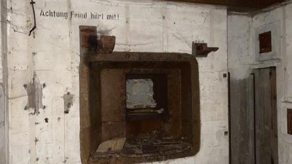 An image inside the bunker with German instructions on the wall reading 'Achtung feind hort mit'