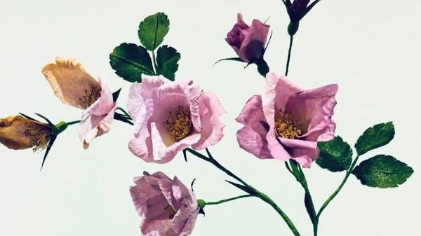 A painted floral display with pink petals and green leaves