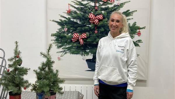 Michelle Clark, the founder of Happy Me Dance, standing in a white jumper and in front of a Christmas tree. She is smiling and looking directly at the camera. 