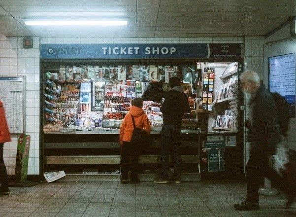  Brixton Underground station ticket hall kiosk shows man and boy queuing under an 'Oyster ticket shop' sign