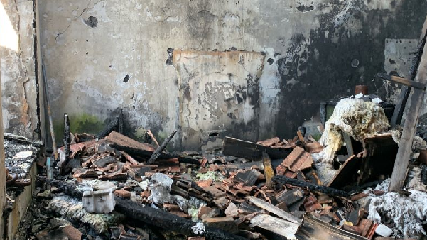 The inside of a building damaged by a fire, with burnt rubble and debris on the ground