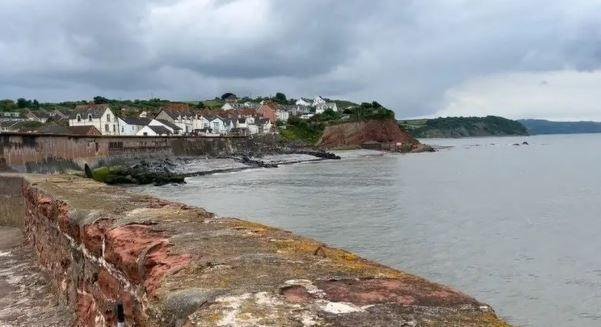 Homes overlooking a grey sea with a grey sky above.