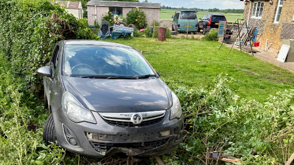 A grey Vauxhall Astra crashed into the garden - with damaged front - the number plate has fallen off- and plants and a hedge have been damaged