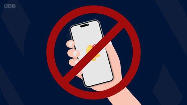 hand holding smartphone with red line through it signifying a ban