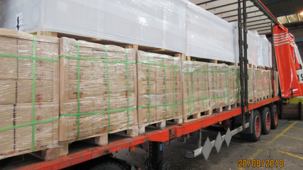 A large lorry laden with pallets of cardboard boxes wrapped in see-through plastic.