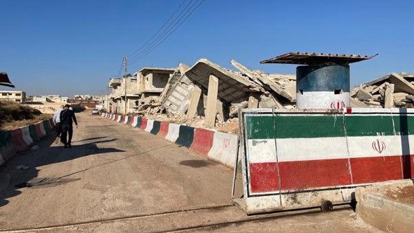 Concrete debris behind a partition painted like the Iranian flag