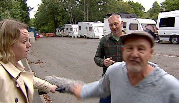 Man shouting at camera, with reporter and another man stood in the background