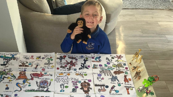 A little boy with 99 animals drawn in front of him for David Attenborough