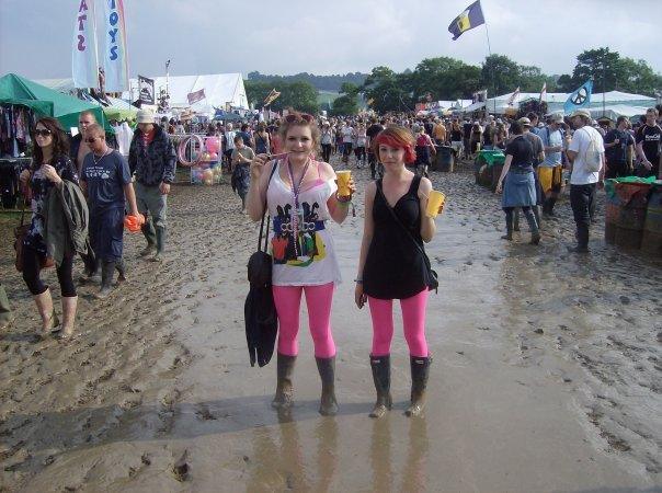 Two women wearing wellington boots standing in mud