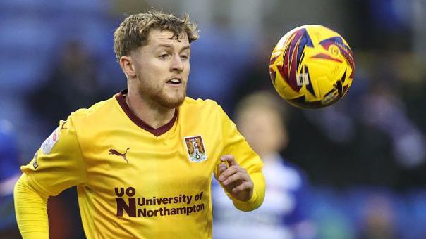  Liam McCarron watches the ball closely as he is about to control it during a match for Northampton Town