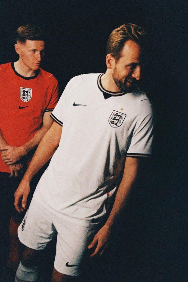 Elliot Anderson (izquierda) viste la equipación roja de visitante mientras posa junto a Harry Kane, que lleva la equipación blanca de local.