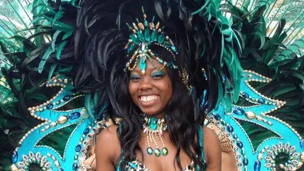 A woman wearing an extravagant blue and green peacock costume at St Pauls Carnival.