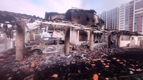 Charred, burnt out cars in what looks to have been a car park