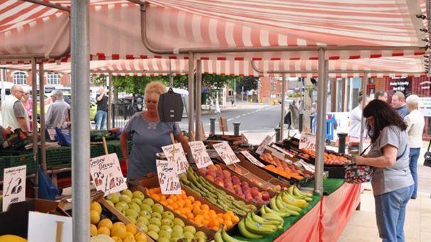 A fruit and vegetable stall at Hucknall Market with people in the background