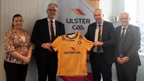 Geraldine McKavanagh, Jarlath Burns, Jon Boutcher, and Brian McAvoy. Jarlath and Jon are both holding an Armagh GAA jersey.