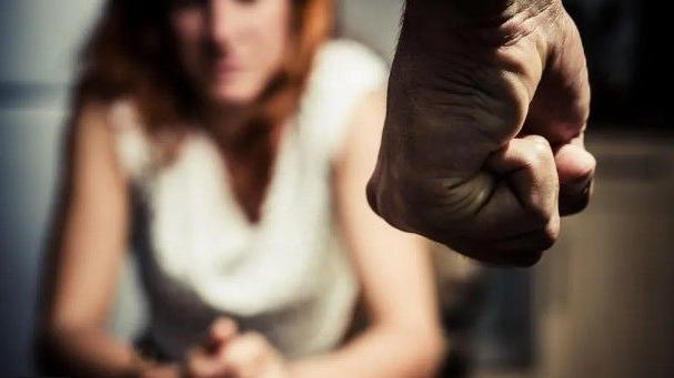 Blurred woman in front of man with his hand in a clasped fist