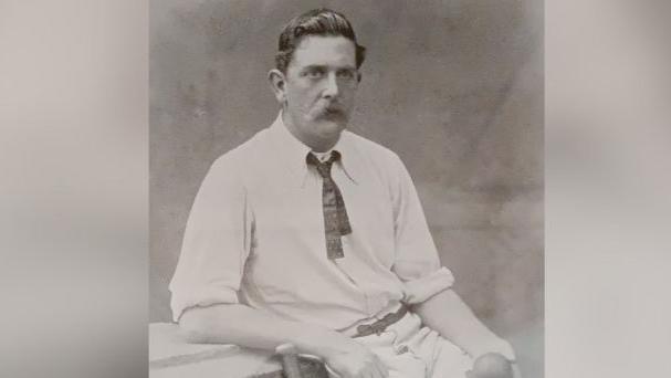 A black and white image of Ted Peate in his cricket whites.