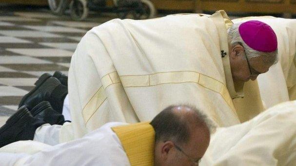 Granada's Archbishop, Francisco Javier Martinez, and other clerics prostrate themselves in front of Granada cathedral's high altar to ask forgiveness for alleged sexual abuses committed by priests on 23 November 2014.