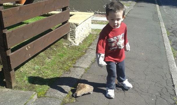 boy next to blasted rock