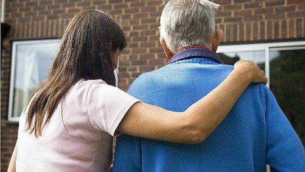 woman with arm around elderly man