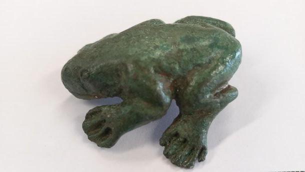 Dark green model of frog showing legs and head