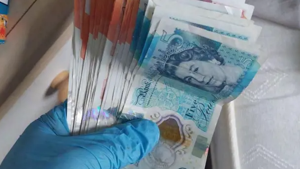 A handful of money, including £5 and £10 notes