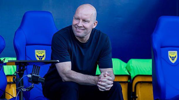Sheffield Wednesday manager Henrik Pedersen smiling and looking relaxed in the dugout