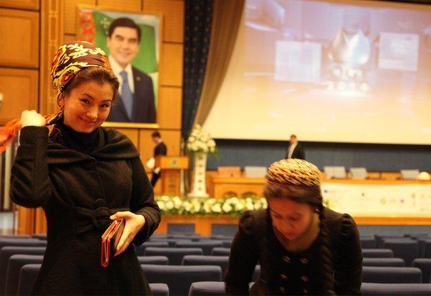 Conference volunteers with portrait of Turkmen president in the background, Ashgabat (Nov 2014)