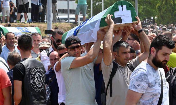 Groups of men in Srebrenica carry the coffins of boys and men killed in the massacre in 1995