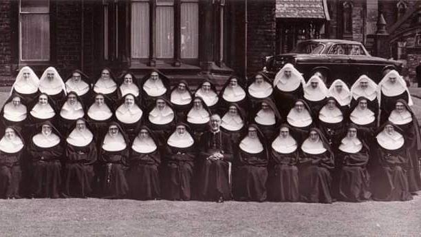 Sisters of Mercy line up in a black and white photograph outside Werneth Grange