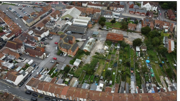 An aerial photograph of terraced houses with gardens backing onto a disused yard