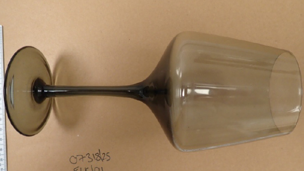 A police evidence image of a wine glass next to two rulers