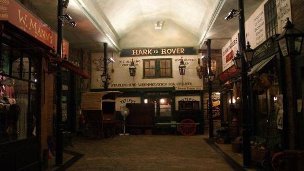 A replica street at Abbey House Museum, with Victorian-style shop fronts and signs, including the Hark to Rover pub at the far end. Other period features, such as lamp posts, can be seen.