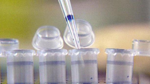 A pipette dripping liquid into a test tube in a laboratory testing