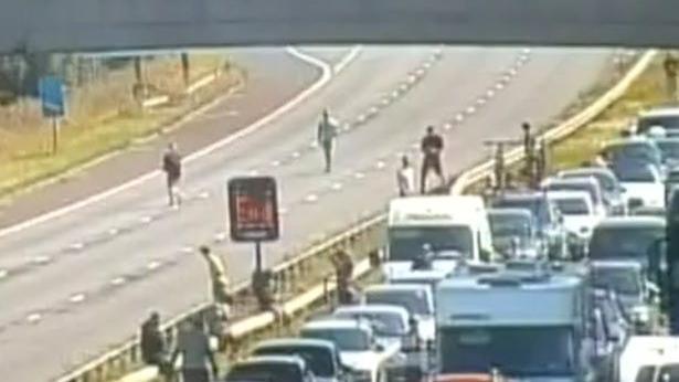 People on motorway after traffic has been stopped