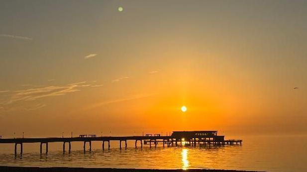 An image of Deal Pier with a setting sun. 