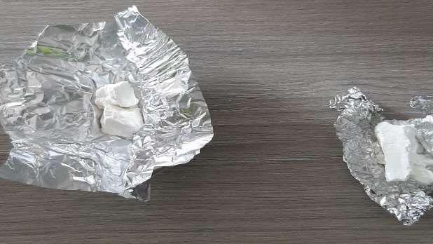 Cocaine is seen sitting on tin foil on top of a table.