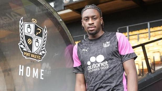 Ethon Archer leaning against the dugout in a Port Vale training top 