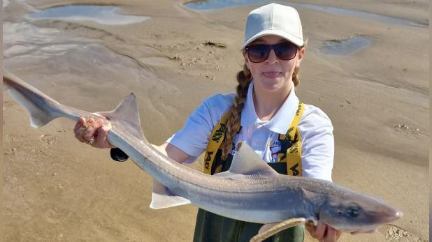 Lexie posing with a small shark 