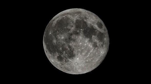 The moon is huge in the centre of the photo, its craters and detail are very visible