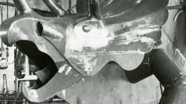 A steel triceratops sits in a warehouse ahead of being placed at the park