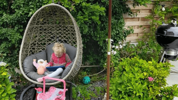 Rose O'Leary Hall reading a book with her dolls 